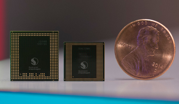 Imagen de dos CPUs de smartphone con una moneda al lado para comparar su tamaño