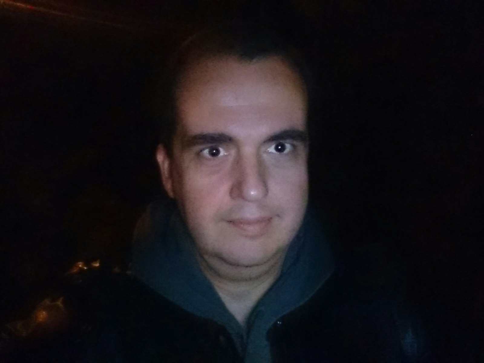 La misma foto de antes, hecha en el mismo lugar, con la misma pobre iluminación ambiental... pero utilizando la app Flash Selfie. ¿Valía la pena para ver a un tío tan feo en la oscuridad? La opinión casi unánime de la redacción de ADSLAyuda es que no, con el voto particular del interesado que afirma lo contrario. Clic para ver a tamaño completo.